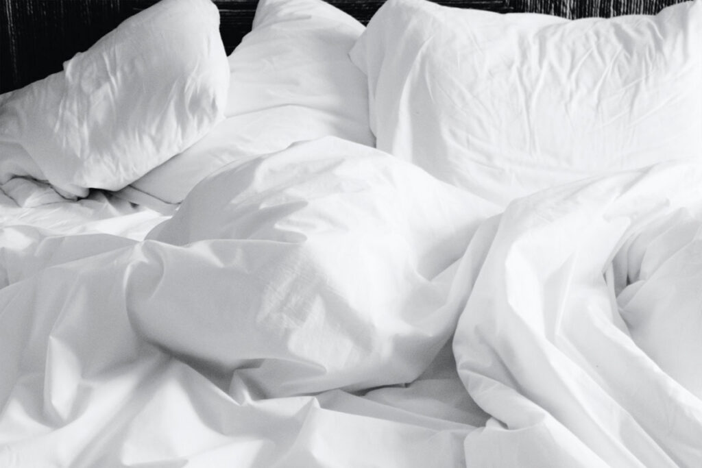 Almohadas blancas sobre cama con fondo negro